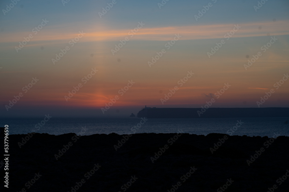 mystical sunset by the sea with a section of coast	