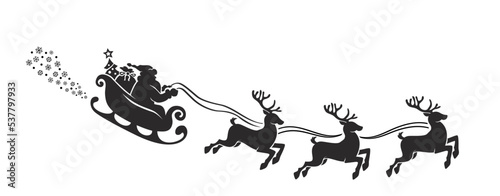 Photographie Silhouette of Santa Claus riding in a sleigh with reindeer