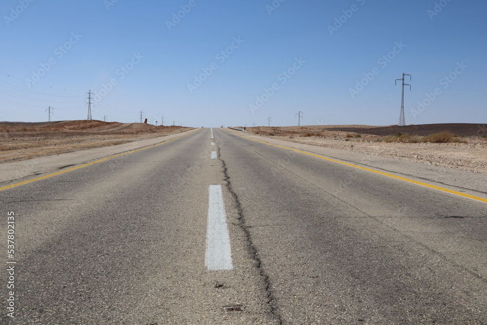Asphalt gray road for car under blue sky in the desert way wasteland during journey to Eilat