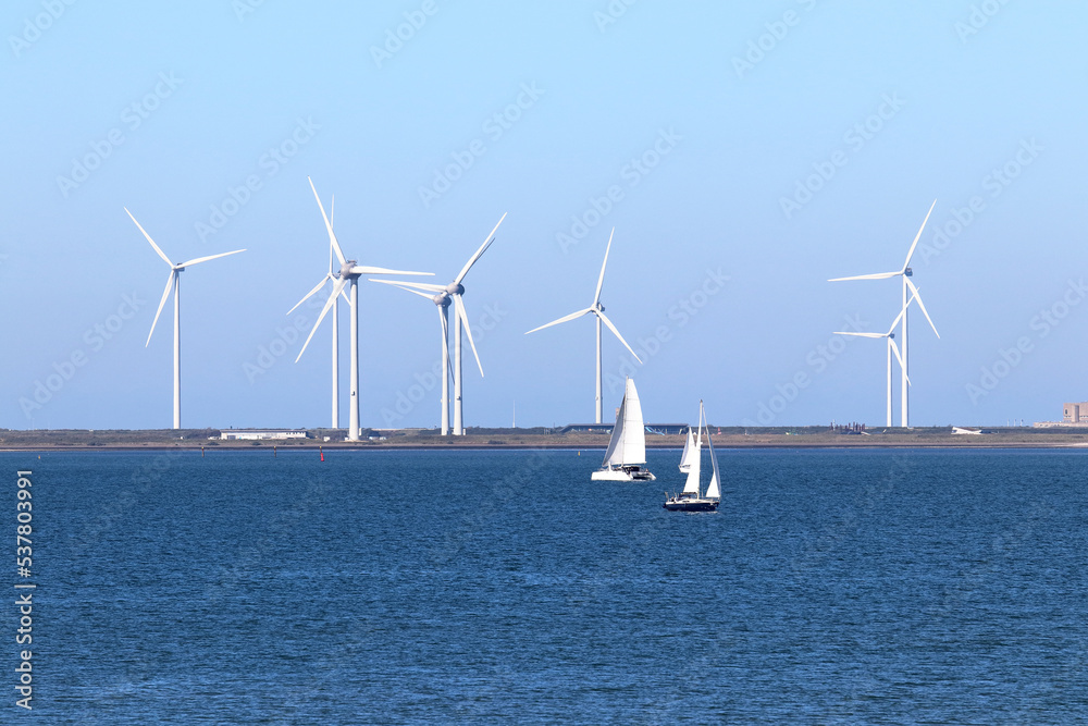 Wind power: sailing ships on the Eastern Scheldt estuary and wind turbines on the storm surge barrier, Netherlands