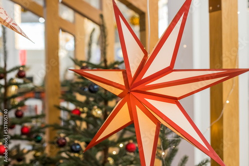 A Christmas star in the window. Warm light, Christmas, cosy atmosphere. Advent time.Paper lightning lantern in star form. new year decoration