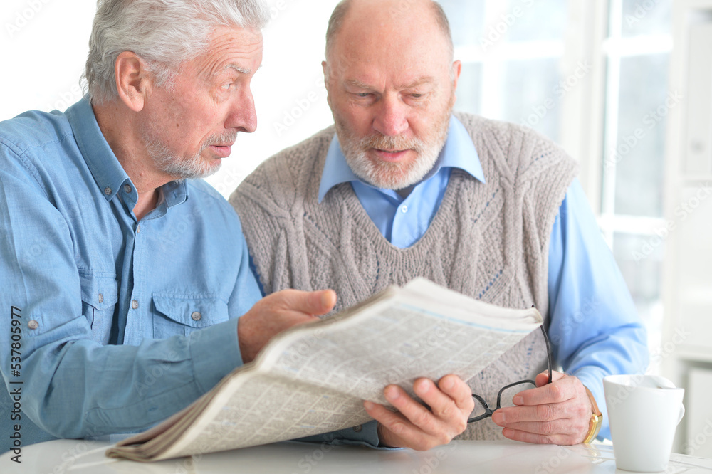 Portrait of two elderly people reading a newspaper Portrait of two elderly people reading a newspaper
