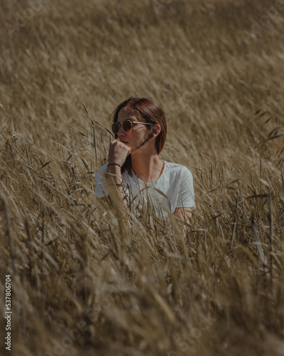 Young female model in Tuscany, Italy. Beautiful woman and green tuscan fields in the background 