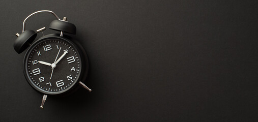 Black friday shopping concept. Top view photo of black alarm clock on isolated black background with copyspace
