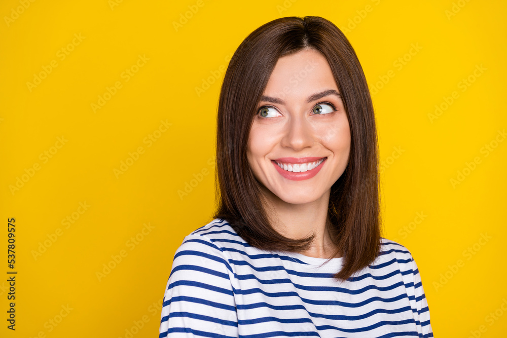 Photo portrait of stunning lovely young woman look smiling empty space wear stylish striped garment isolated on yellow color background Photo portrait of stunning lovely young woman look smiling empty space wear stylish striped garment isolated on yellow color background