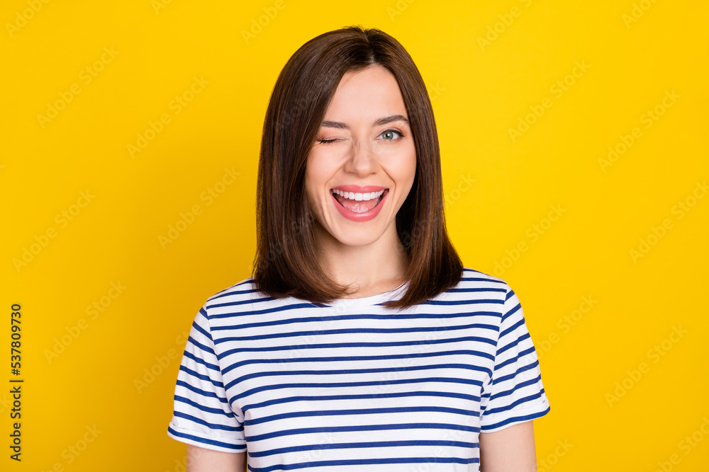 Fototapeta premium Photo portrait of nice young woman excited wink toothy smile good mood dressed trendy striped clothes isolated on yellow color background