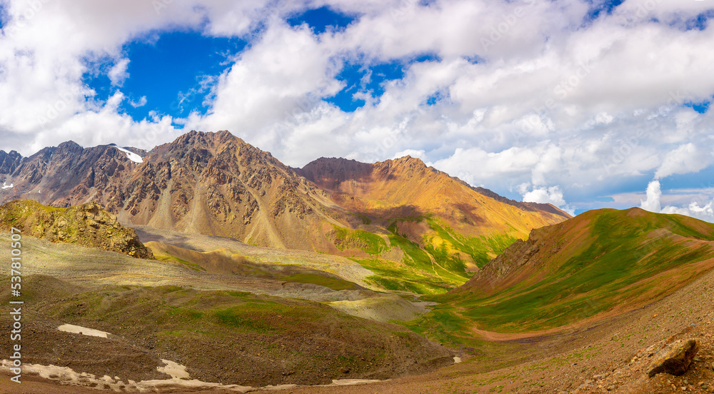 Beautiful nature of the rocky mountains. Mountain nature landscape. Rocks on the background of the sky with clouds. Mountain valley with green hills. Beautiful nature of the rocky mountains. Mountain nature landscape. Rocks on the background of the sky with clouds. Mountain valley with green hills.
