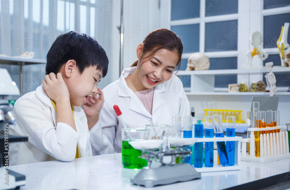 Asian boy and female teacher learn to experiment with mixing liquids in tubes. Science Asian boy and female teacher learn to experiment with mixing liquids in tubes. Science