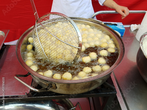 Cooking fry curd balls in boiling hot oil. Turkish donuts Lokma