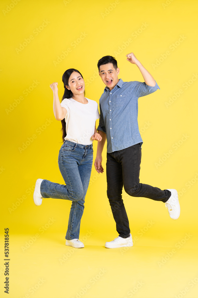 Fototapeta premium full body image of asian couple posing on yellow background