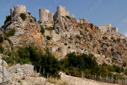 View of the old part of the castle Yılan Kalesi, which is located on a high rock, against a blue sky, near the city of Adana in the Southern Turkey photo