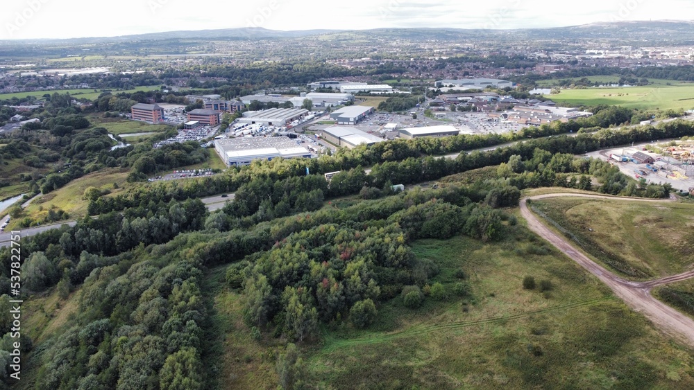 Aerial view of an industrial factory surrounded by green fields and trees. Taken in Bury Lancashire. 