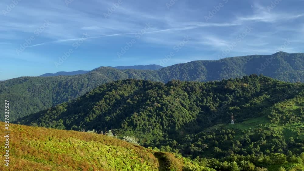 Mountains aesthetic panorama view from above. Peak of Gonio mountain in Adjara, Georgia. Blue sky with clouds, green valley and red woods Mountains aesthetic panorama view from above. Peak of Gonio mountain in Adjara, Georgia. Blue sky with clouds, green valley and red woods