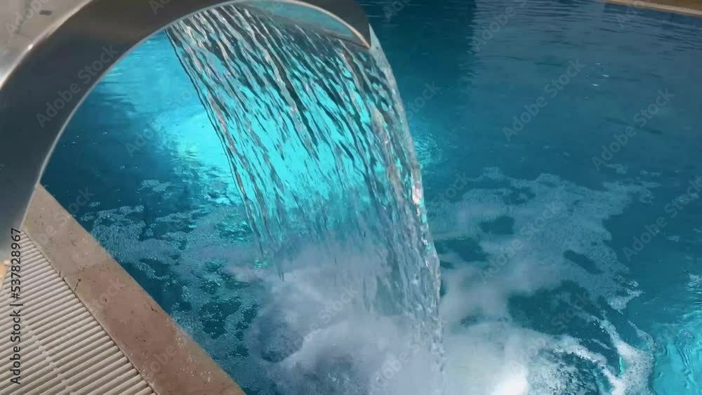 Empty Swimming pool with waterfall jet and jacuzzi in action Empty Swimming pool with waterfall jet and jacuzzi in action