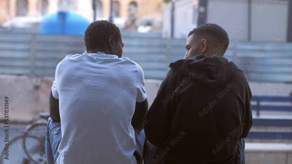 Consoling a friend: back view of a tunisian man comforting a sad african man
