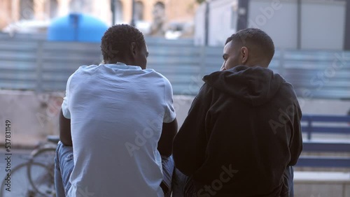 Consoling a friend: back view of a tunisian man comforting a sad african man