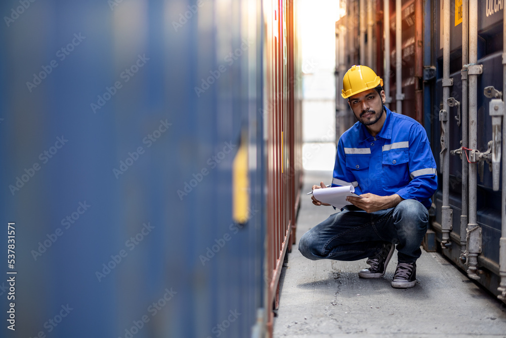 Container operator holding a notepad while doing his daily inspection in the container yards.