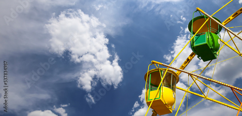 Attraction (carousel) ferris wheel on the background of the cloudy sky photo