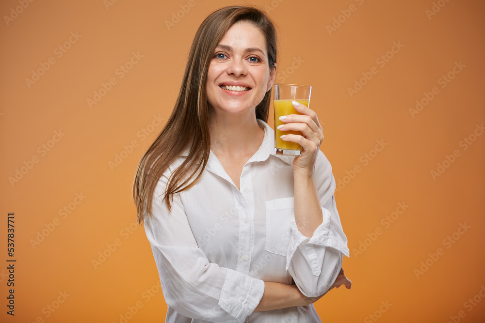 Smiling woman wearing white shirt holding orange juice glass. Isolated female advertising portrait. Smiling woman wearing white shirt holding orange juice glass. Isolated female advertising portrait.