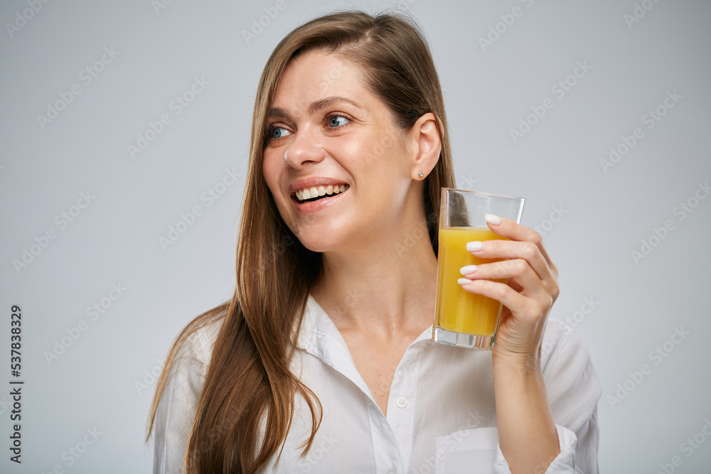 Smiling woman holding orange juice glass looking side away. Isolated female advertising portrait. Smiling woman holding orange juice glass looking side away. Isolated female advertising portrait.