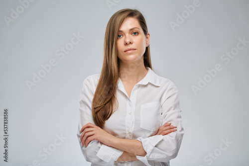 Portrait of serious woman in white shirt.