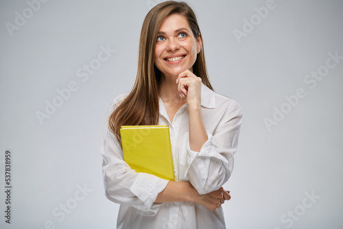 Student or teacher woman looking up holding yellow book, isolated female portrait.