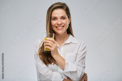 Smiling woman holding orange juice glass. Isolated female advertising portrait.