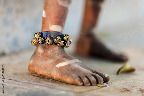 Fototapeta Naklejka Na Ścianę i Meble -  Child's bare foot wearing bells around the ankle, Close-up view, Udaipur, Rajasthan, India