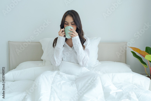 Beautiful girl sitting and drinking hot tea in the morning.