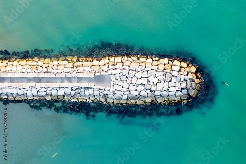 Photography Top view of the green water around a rocky breakwater