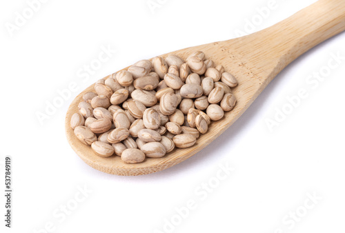 Brown beans on a spoon isolated over white background