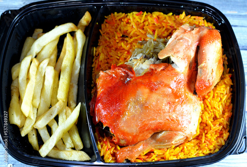 Chicken mandi with long basmati rice and french fries, served with tomato dakos sauce, selective focus of Yemen recipe of Mandi chicken with spices and sauce isolated photo