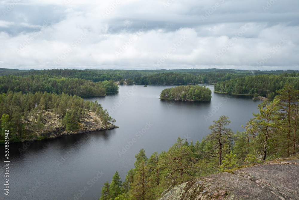 Soft focus image of fog raising over the lake, rocks and forest in the Repovesi National Park after the rain on cloudy summer day. View from Katajavuori Hill
