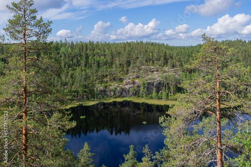 Fototapeta Naklejka Na Ścianę i Meble -  View from Hauklamminvuori Hill to the Hauklampi lake, rocks and forest in the Repovesi National Park on sunny summer day