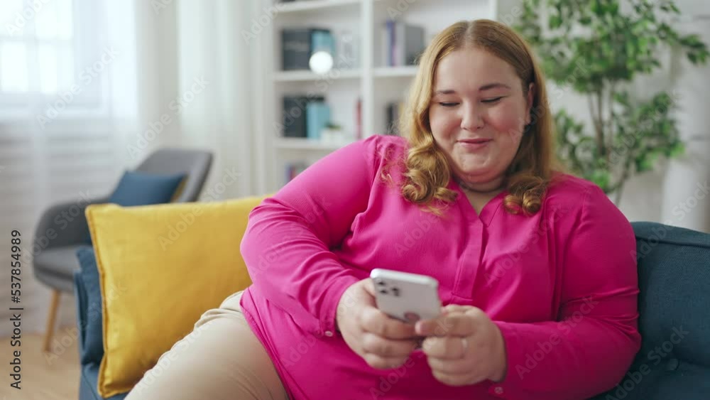 Happy curvy woman using mobile app on smartphone, enjoying online shopping Happy curvy woman using mobile app on smartphone, enjoying online shopping