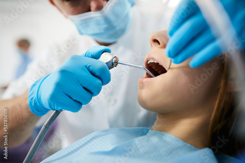 Close up of teenage girl having her teeth checked by dentist at dental clinic.