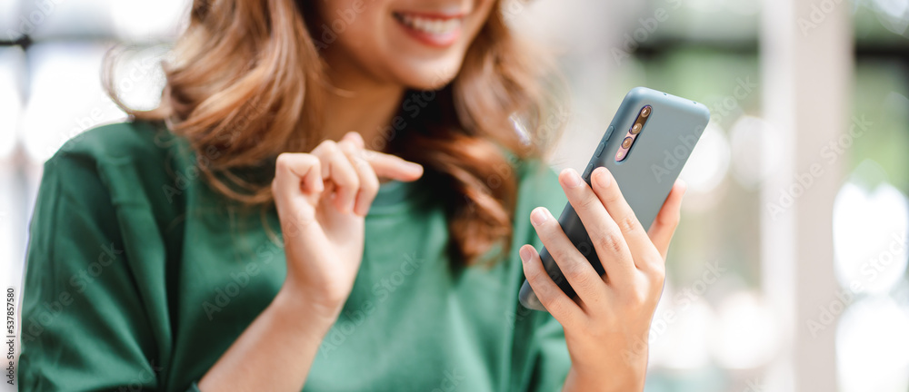 Portrait of an Asian woman holding a smartphone, typing messages, chatting with friends. on social networks mobile application concept Shopping online, browsing the web, ordering food