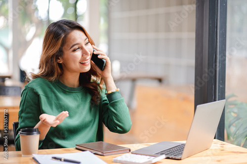 Asian businesswoman chatting on smartphone, auditor, document search, report, analysis, tax, accounting, document, data, contract, agreement at work.