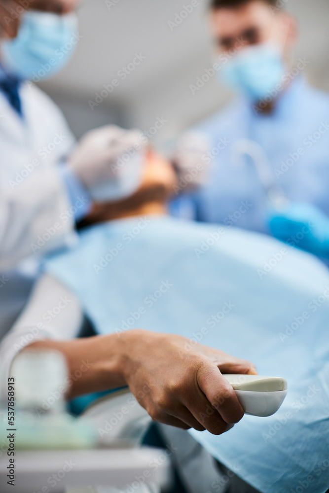 Close up of woman in pain holds tight to chair during procedure at dentist. Close up of woman in pain holds tight to chair during procedure at dentist.