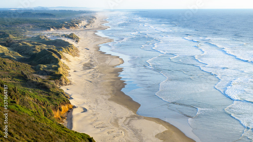 Scenic view along coastline as sandunes reach the Pacific Ocean at Baker Beach near Florence Oregon photo
