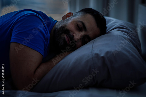 Handsome peaceful man sleeping in his bed 