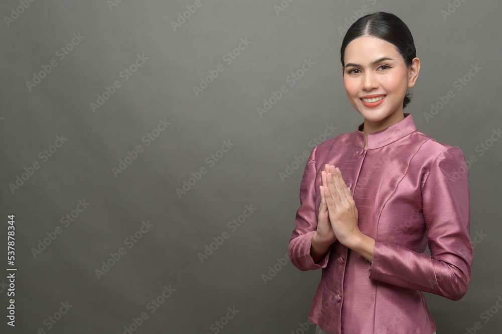 A young asian woman wearing Thai traditional cloth on gray background A young asian woman wearing Thai traditional cloth on gray background