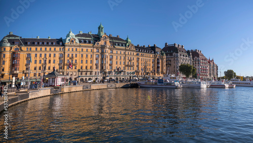 View over the pier with boats and apartment houses at the bay Ladugårdsviken a sunny a color full autumn day in Stockholm