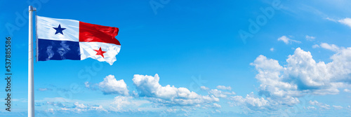 Panama flag waving on a blue sky in beautiful clouds - Horizontal banner
