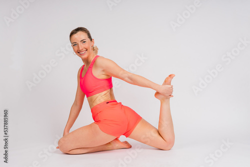 Full length portrait of smiling young woman in sportswear isolated over studio background. © Ivan Zelenin