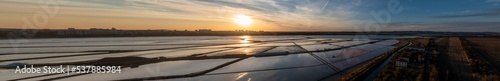 Panoramic Drone Shot of a sunset over a salt works near the ocean