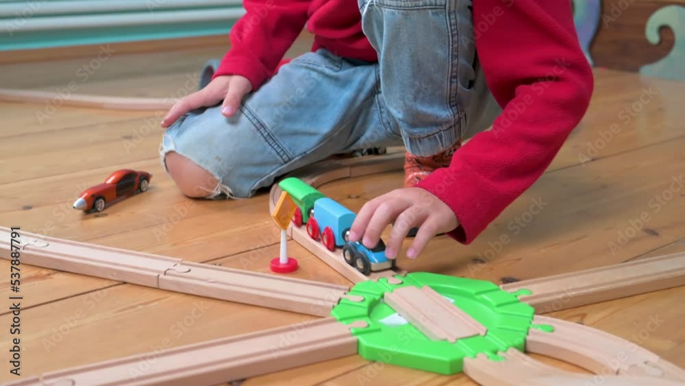 Little boy playing with wood railroad. 4k video footage 