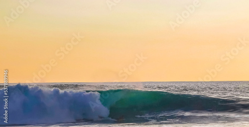 Colorful golden sunset big wave and beach Puerto Escondido Mexico.