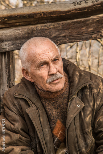 Mature man on ruins of wooden house