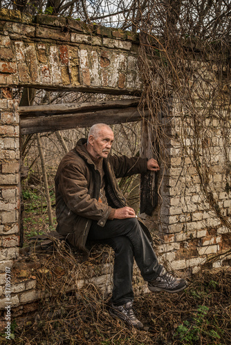Mature man on ruins of wooden house